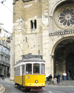 Iconic yellow tram navigating the streets of Lisbon, Portugal, showcasing the city’s historic charm